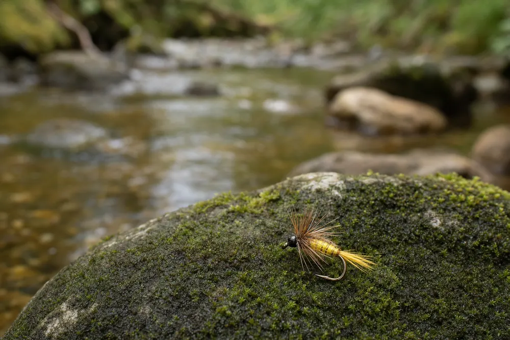 Beginner fly patterns tied in a rotary vise, ready to fish a river